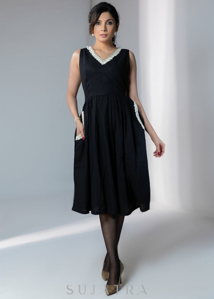 Black sleeveless rayon dress with off white lace detailing on neck and pockets