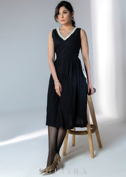 Black sleeveless rayon dress with off white lace detailing on neck and pockets