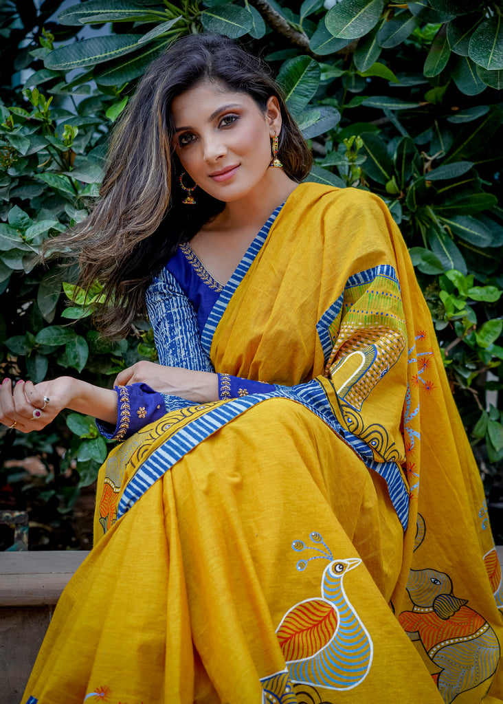 Elegant mustard cotton Gond hand painted saree with indigo border