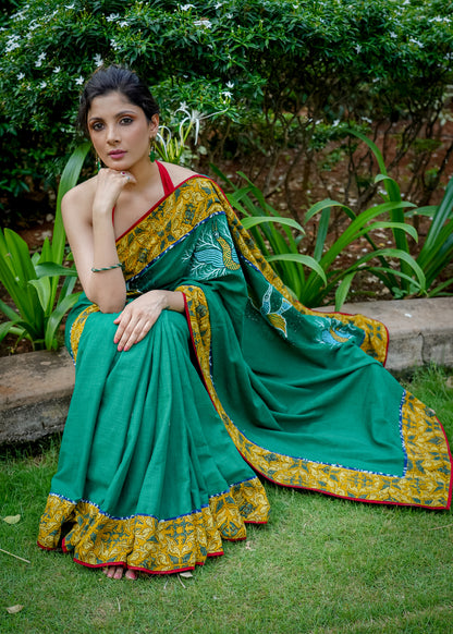 Cotton bottlegreen saree with gond hand painting with Ajrakh border