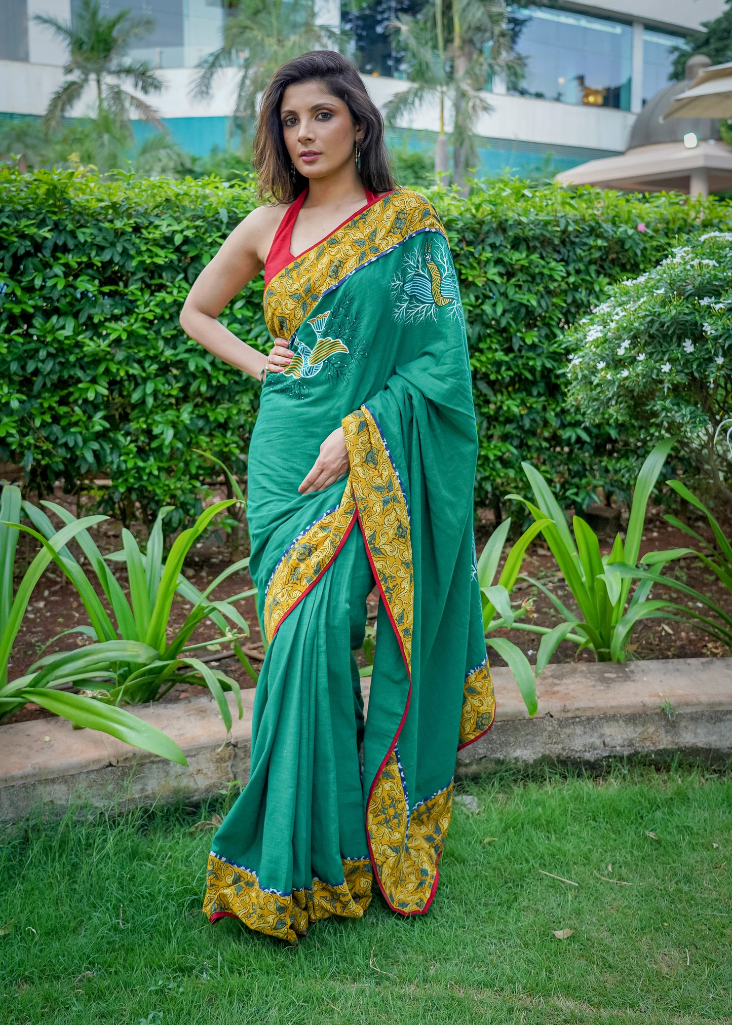 Cotton bottlegreen saree with gond hand painting with Ajrakh border