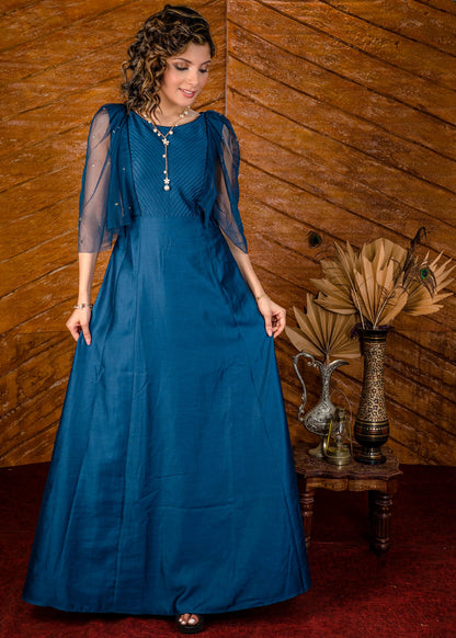 Blue satin gown with net sleeves, sequence work & self tucks on yoke.